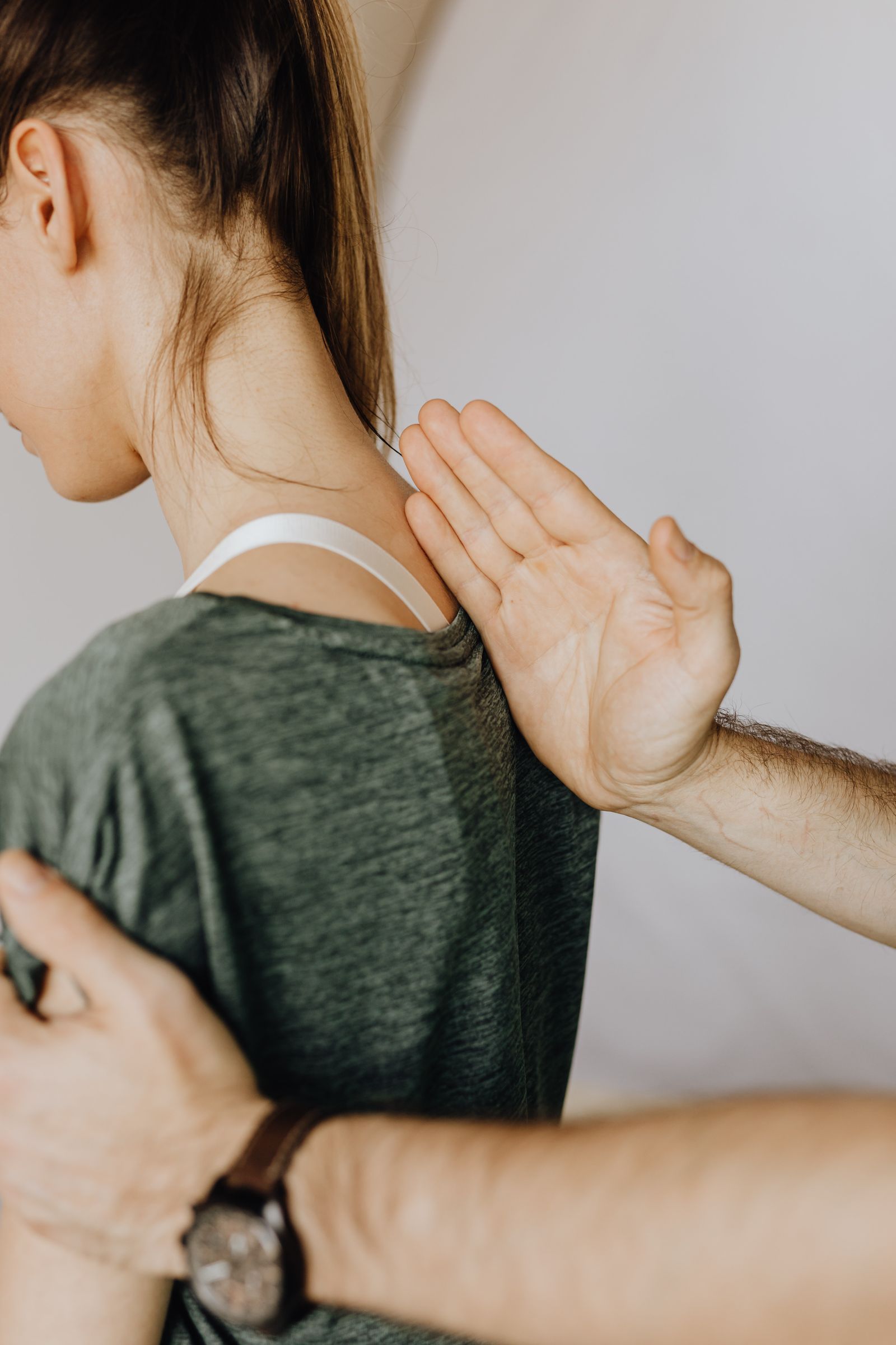 Fisioterapeuta tratando la espalda y el cuello de un paciente — contractura muscular